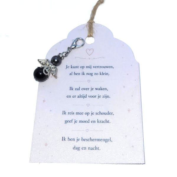 Een donkerzilverkleurig beschermengeltje hangertje met een zwarte onyx steentje en een Swarovski parel, samen met een kaartje waarop een persoonlijk gedicht is geschreven.
