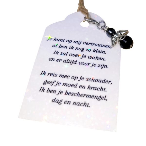 Een donkerzilverkleurig beschermengeltje hangertje met een zwarte onyx steentje en een Swarovski parel, samen met een kaartje waarop een persoonlijk gedicht is geschreven.