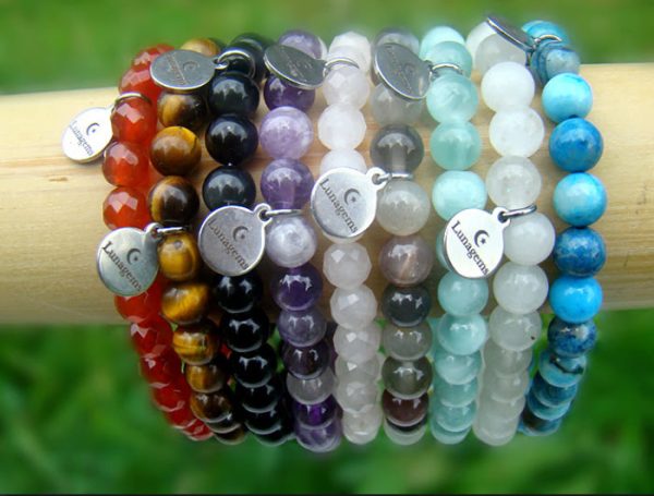 Negen elastische armbanden met carneool, tijgeroog, regenboog obsidiaan, amethist, rozenkwarts, maansteen, groene angeliet, witte jade en blue crazy agaat kralen.