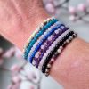 Stainless steel armbanden met edelstenen amazoniet, amethist, apatiet, gouden driehoek, onyx, regenboogmaansteen, rozenkwarts en toermalijn gedragen om pols