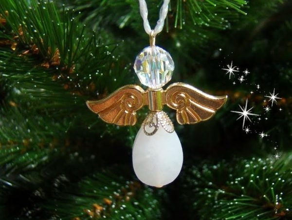 Goudkleurige kerstengel van een witte jade druppel en Swarovski parel in een kerstboom.