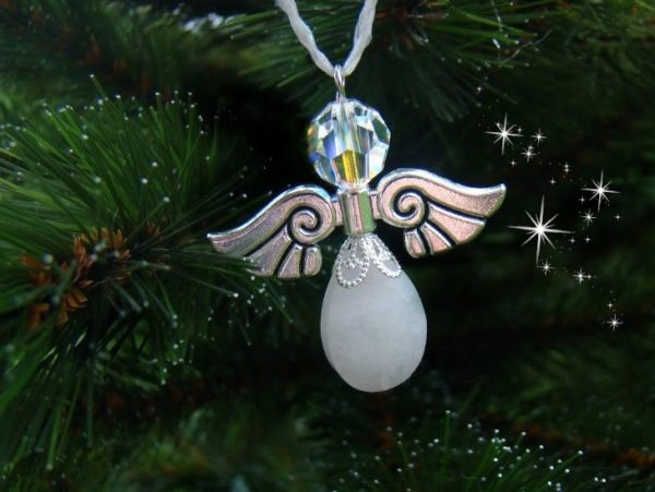 Donkerzilverkleurige kerstengel van een witte jade druppel en Swarovski parel in een kerstboom.