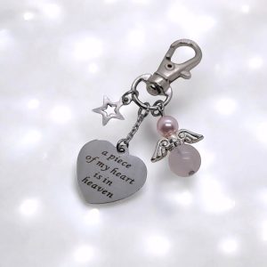 Een sleutelhanger met tekst bedel hartvormig A piece of my heart is in heaven met beschermengeltje rozenkwarts + Swarovski parel