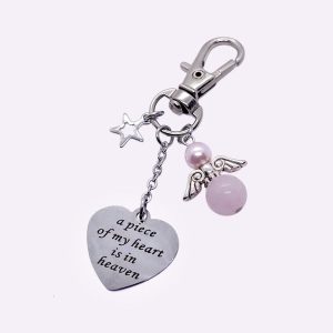Een sleutelhanger met tekst bedel hartvormig A piece of my heart is in heaven met beschermengeltje rozenkwarts + Swarovski parel