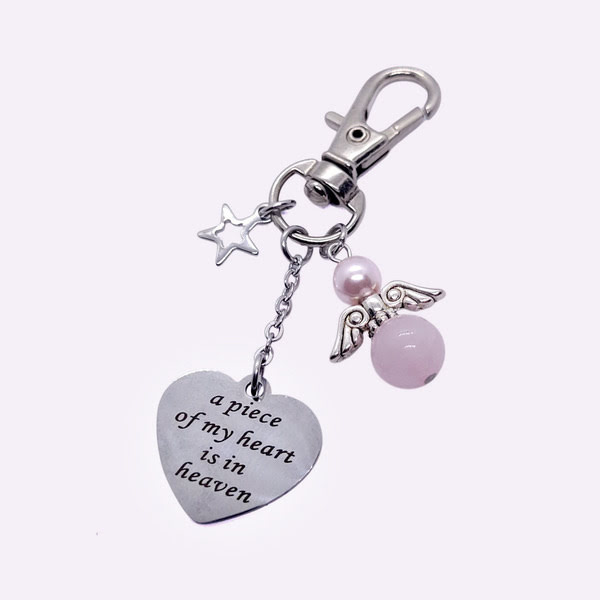 Een sleutelhanger met tekst bedel hartvormig A piece of my heart is in heaven met beschermengeltje rozenkwarts + Swarovski parel