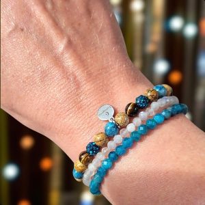 Armbandenset met een geknoopte armband van jaspis, blue crazy agaat, tijgeroog en rhinestone, gecombineerd met verstelbare armbanden van regenboogmaansteen en apatiet.