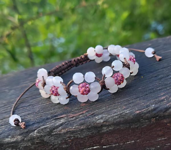 Een bruine armband met lichtroze bloemetjes van kralen
