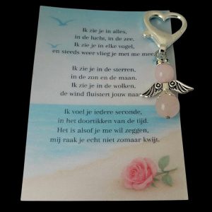Troostengeltje van rozenkwarts met kaartje met zelfgeschreven gedicht met zee achtergrond en roos.