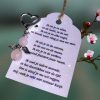 Donkerzilverkleurig beschermengeltje van rozenkwarts met een kaartje met een zelfgeschreven troostgedicht.