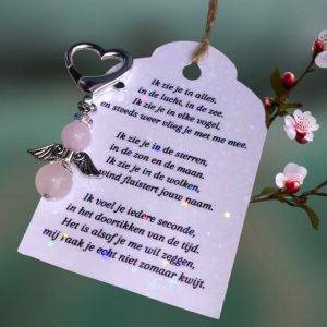 Donkerzilverkleurig beschermengeltje van rozenkwarts met een kaartje met een zelfgeschreven troostgedicht.