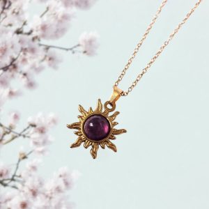 Gouden stainless steel ketting met een zon hanger met amethist steen.