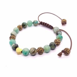 Geknoopte armband van bruin waxkoord met groene edelsteen en rhinestone kralen.