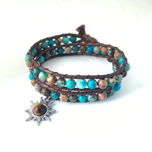 Wikkelarmband gemaakt van bruin waxkoord, geverfde zeekleurige Imperial jaspis kralen en stainless steel tijgeroog zonnetje