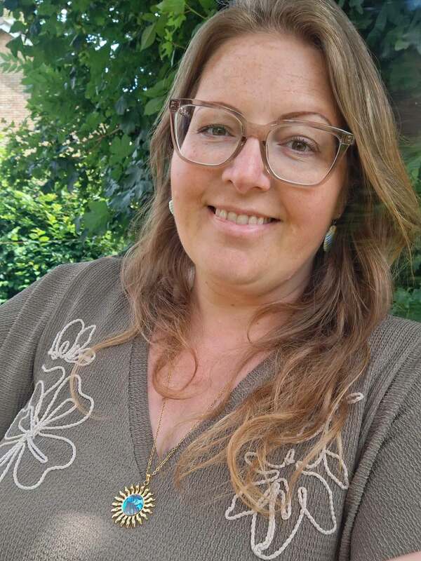 Vrouw met gouden ketting met abalone schelp zon